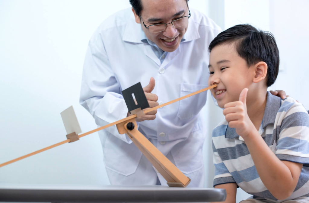 An optometrist helping a young boy with vision therapy treatment.
