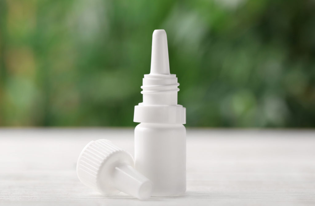 A bottle of Atropine eyedrops on white wooden table against a blurred background.