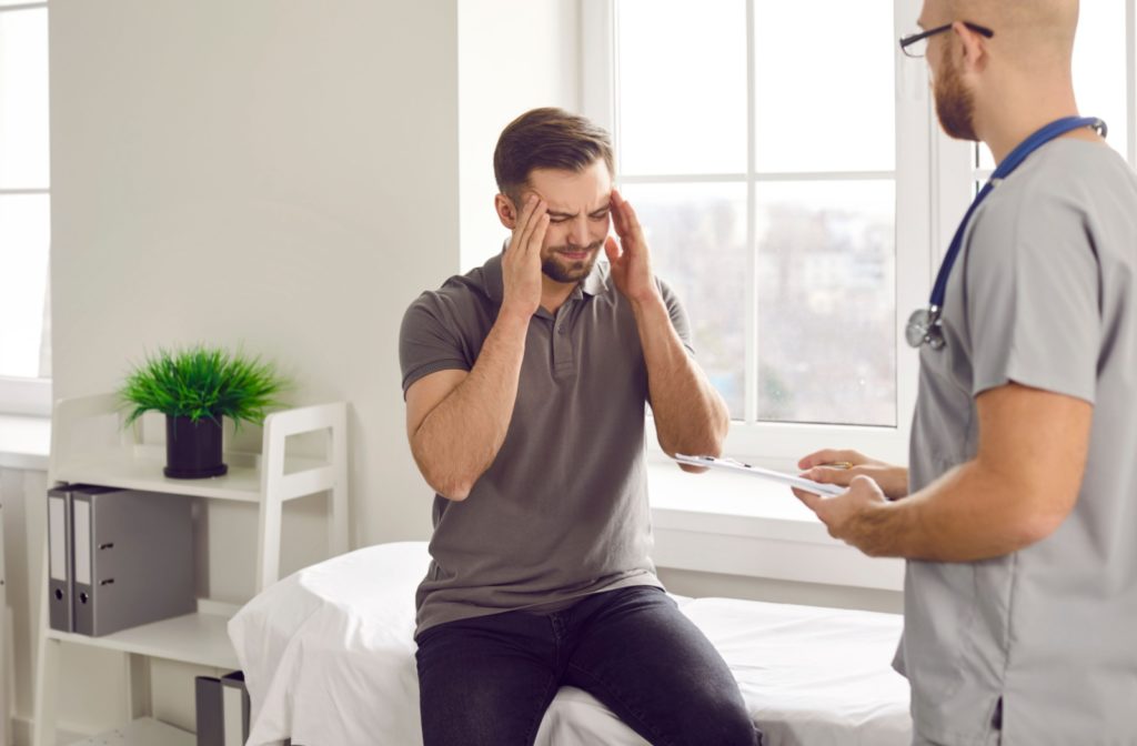 a man is at a physician's office getting examined for a head injury which may impact his vision