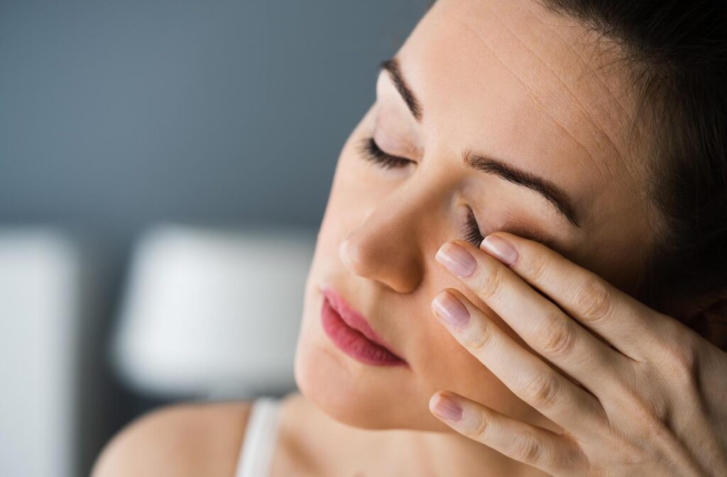 A person holding their swollen eye.